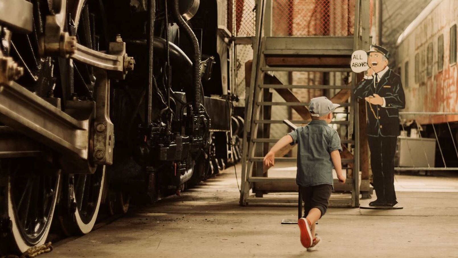 Here is a little boy exploring the Elgin County Railway Museum. The little boy is running toward the paper cut out of a caption calling 