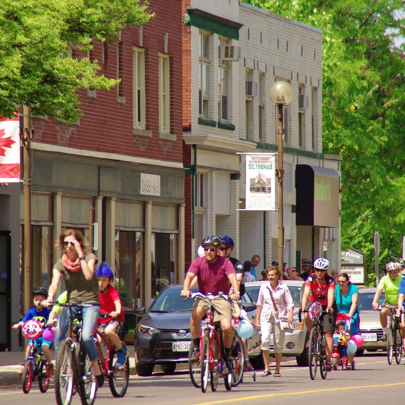 The downtown strip featuring individuals biking down the street towards the camera. 